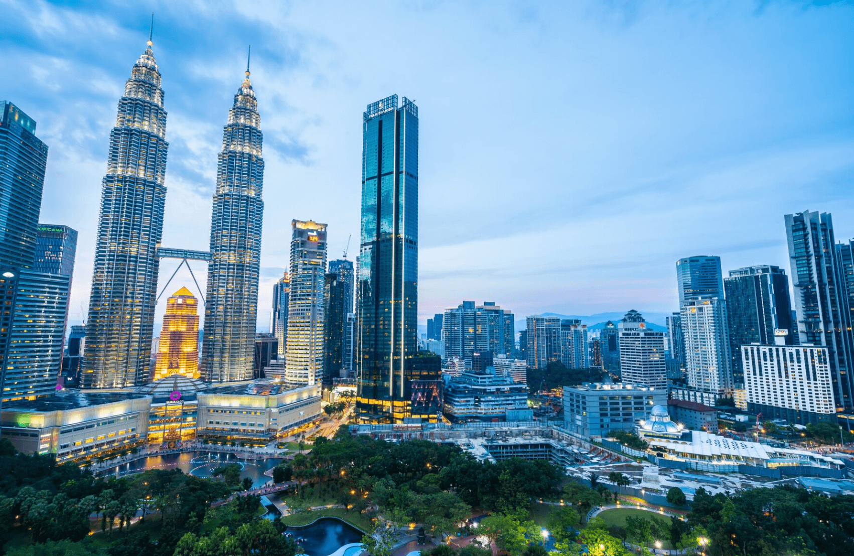 Twilight cityscape with illuminated skyscrapers and Petronas Towers.